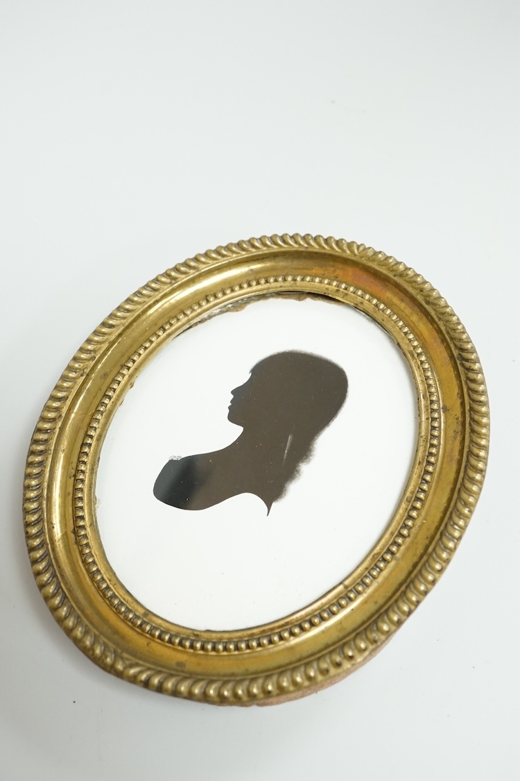 Mrs Mary Lightfoot (18th. C), oval painted silhouette portrait of a young lady, on plaster, printed trade label verso, embossed brass frame, overall 12cm high